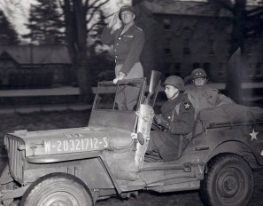 General Patton
              im Jeep stehend nimmt in der Normandie Truppen ab, 1944