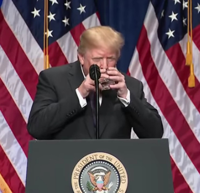 Trump trinkt Wasser und h�lt dabei das Glas mit beiden H�nden, er kopiert den kriminellen Greis Soros