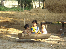Bangladesh, village of Misripara, children
                      on a swing