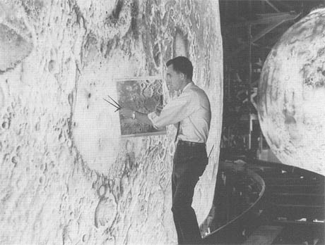 El modelo
                        de la luna LOLA con el tren alrededor de la
                        luna, m�s al fondo otro planeta artificial; foto
                        del 1/8/1965, foto de la NASA L-65-5579. Fotos
                        con el c�digo "L" son de la
                        instalaci�n de simulaci�n de Langley.