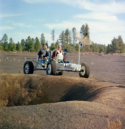 Irwin (izquierda) y Scott (derecha) con el
                        carro lunar de entrenamiento (Lunar Roving
                        Vehicle Simulator, "1g trainer") en
                        una excursi�n geol�gica en un campo de cr�teres
                        de Cinder Lake en Arizona al margen de un cr�ter
                        de 30 pies, 02-03/11/1970, foto 02