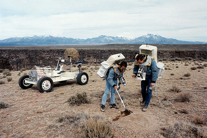 Entrenamiento para Apolo 15, foto de la
                        NASA S71-23772, una excursi�n EVA en un
                        territorio similar a la luna en Taos al margen
                        del R�o Grande (Nueva M�xico): Irwin toma
                        pruebas del suelo con una pala, Scott tiene una
                        bolsa para la prueba. Al fondo hay el carro
                        lunar de entrenamiento "Grover",
                        11-12/03/1971, fecha del cat�logo 03/11/1971