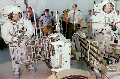 Entrenamiento para Apolo 15, foto de la
                        NASA no. 71-HC-722: Irwin trabajando con una
                        instalaci�n del fondo del "carro
                        lunar", Scott trabajando con una pel�cula
                        de la c�mara