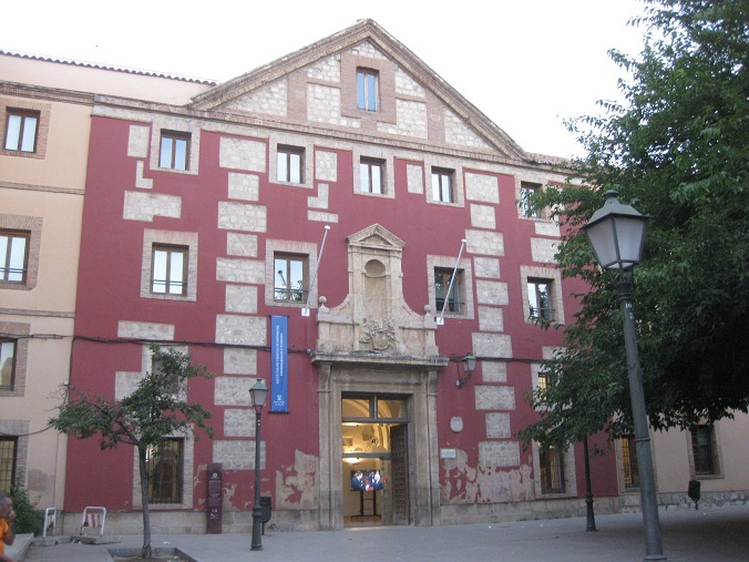 Alcal�, cerca de Madrid: una escuela mon�stica
                  con un Jes�s de fantas�a enlucida y pintada de rojo
                  oscuro, con manchas rojas brillantes con los ladrillo