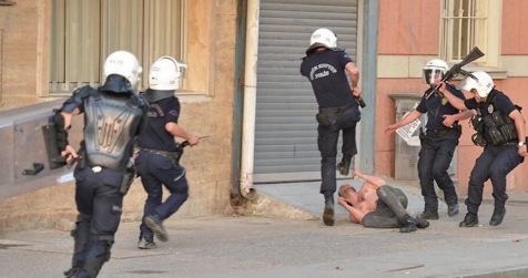 T�rkische Schl�gerpolizei 31, drei
                          Marsmenschen bek�mpfen einen Demonstrant ohne
                          Hemd, der bereits am Boden liegt
